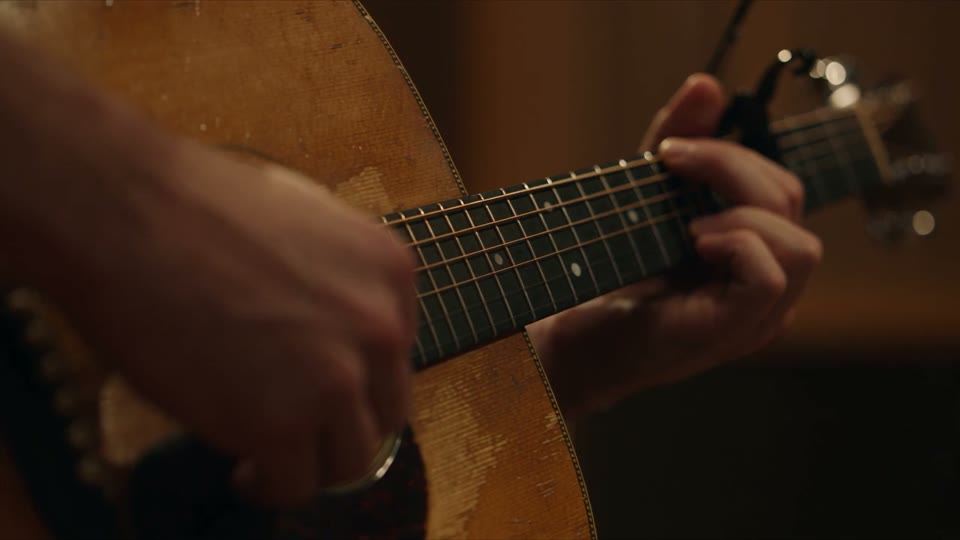 An intimate studio film with guitar, tape meters and a microphone