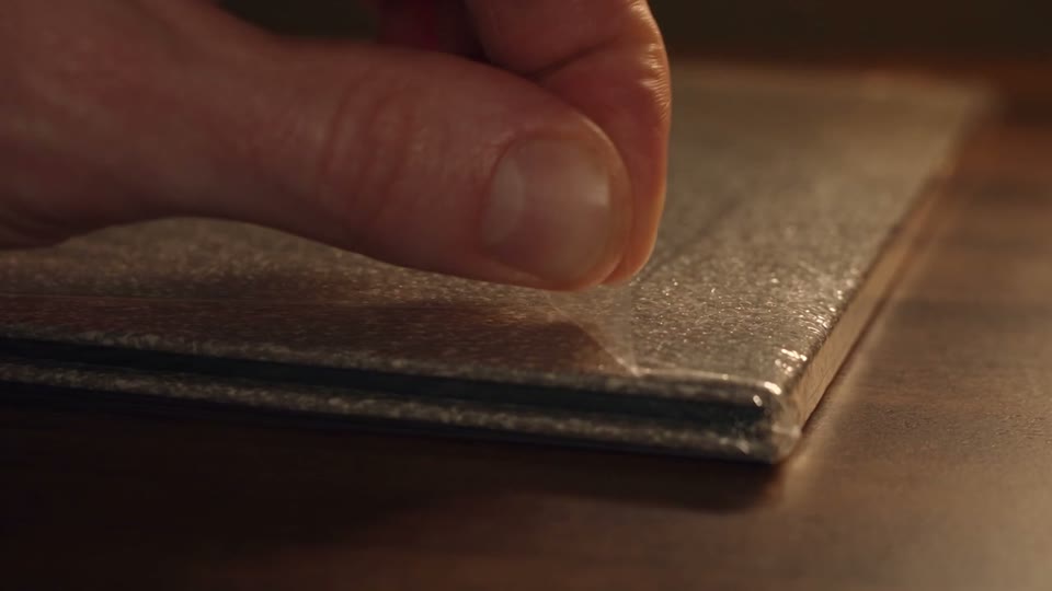A tactile close-up film of opening and playing a record