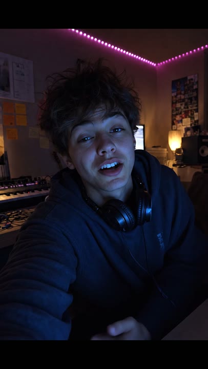A creator speaking directly to camera in a dim music studio